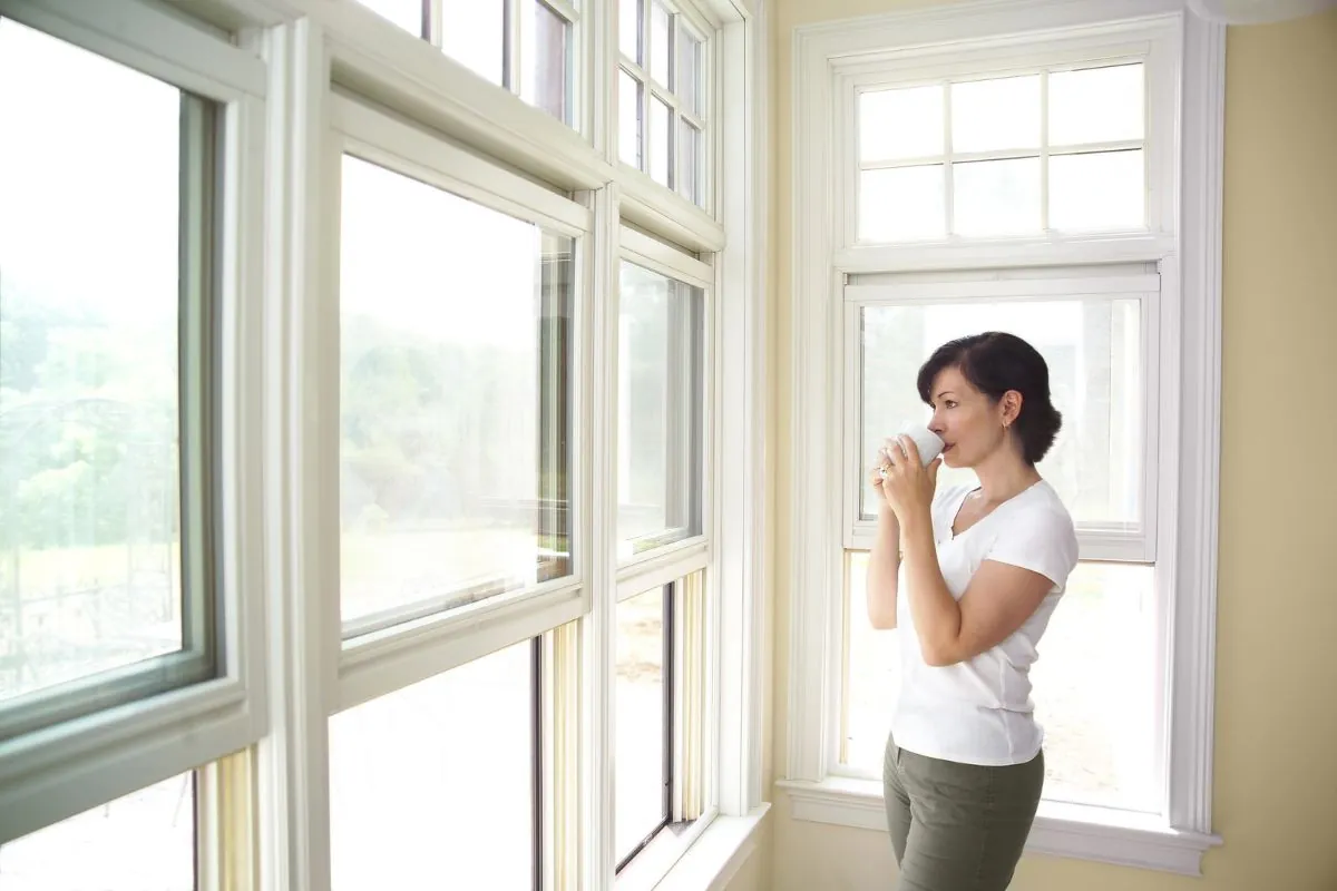 woman standing near double hung window