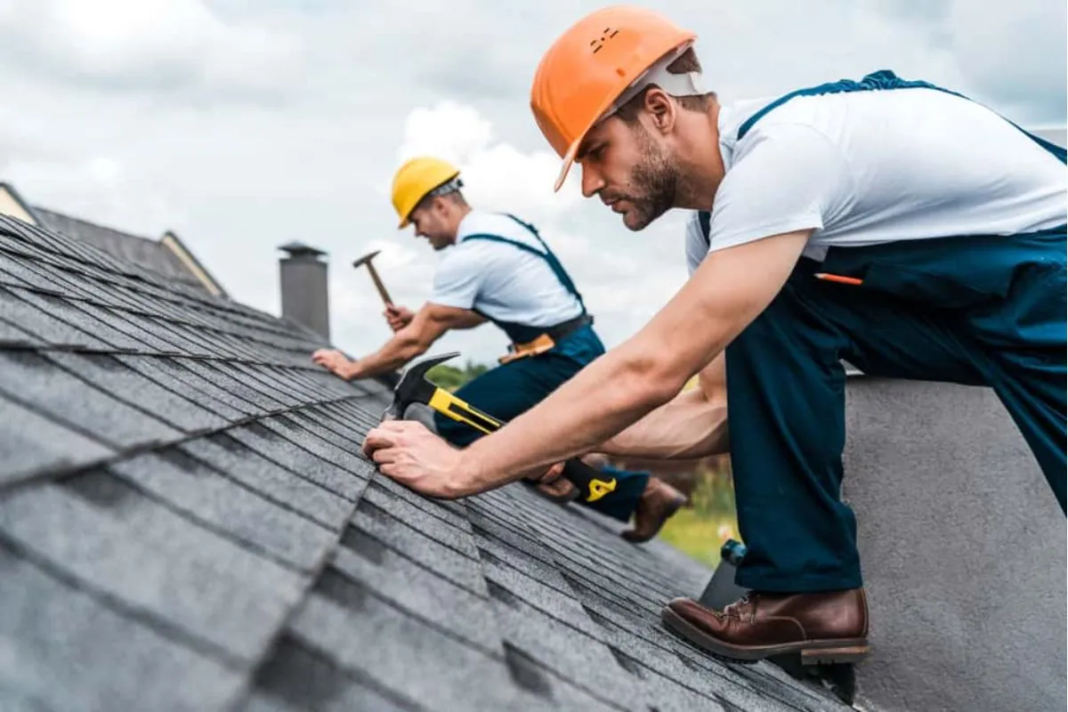 two contractors repairing roof shingles