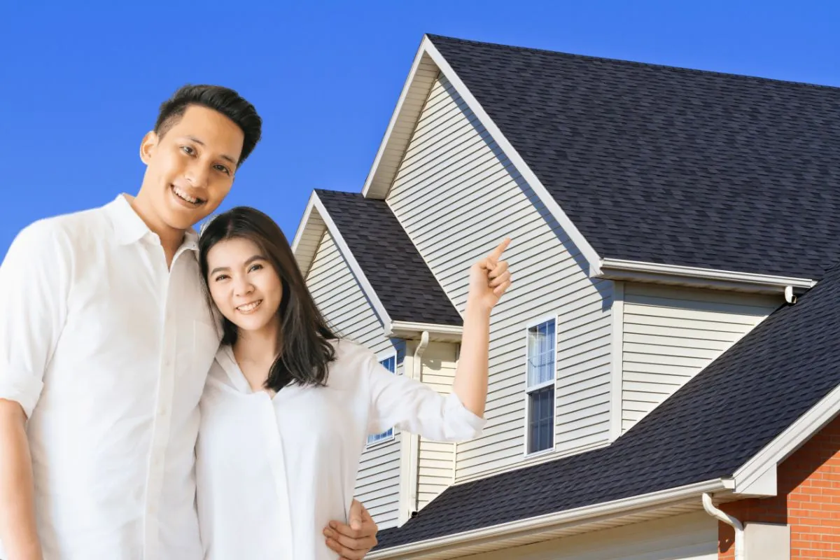 happy couple pointing on new roofing construction